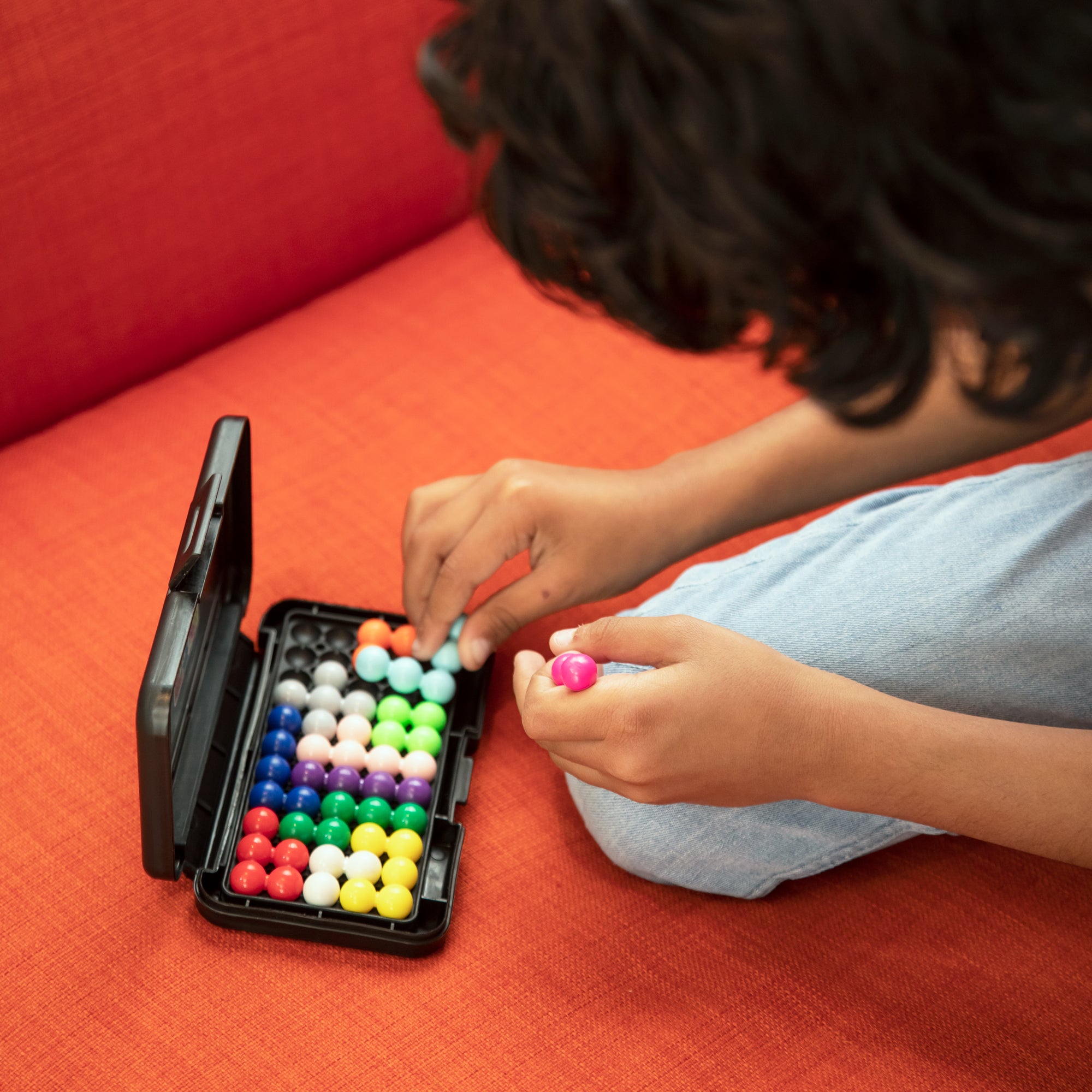 A child arranging pieces to solve the Kanoodle Game