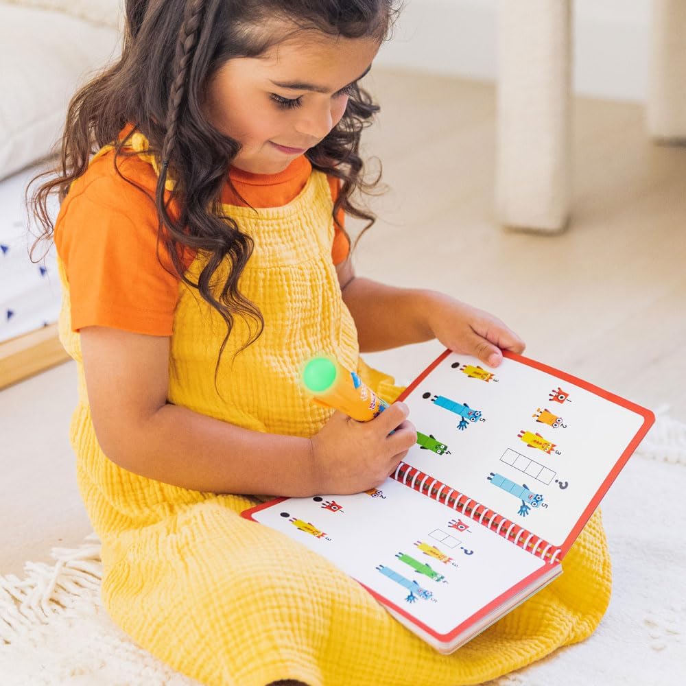 A child interacting with the Numberblocks Hot Dots 1-10 Activity Book & Interactive Pen