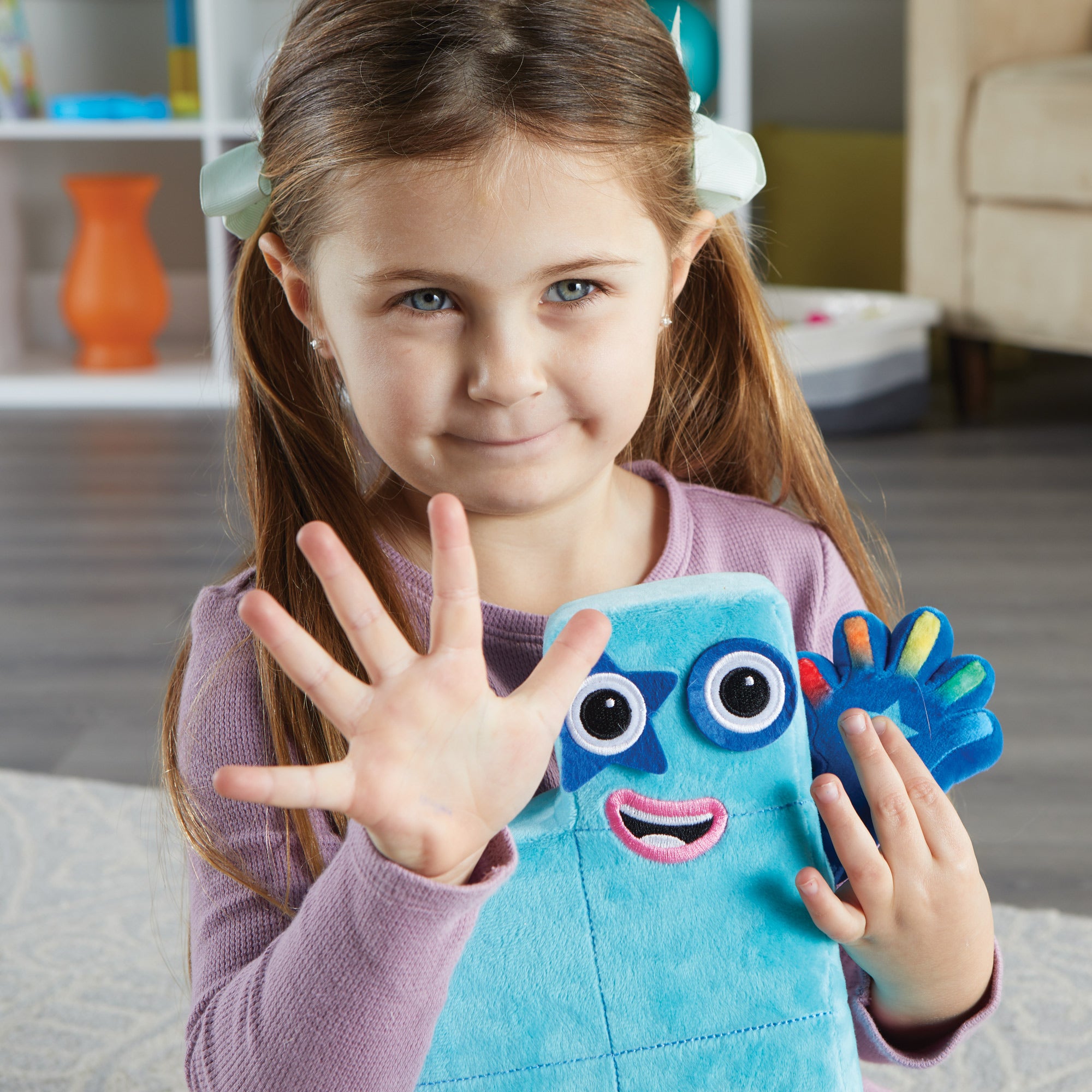 A child posing with Numberblocks Number Five Plush