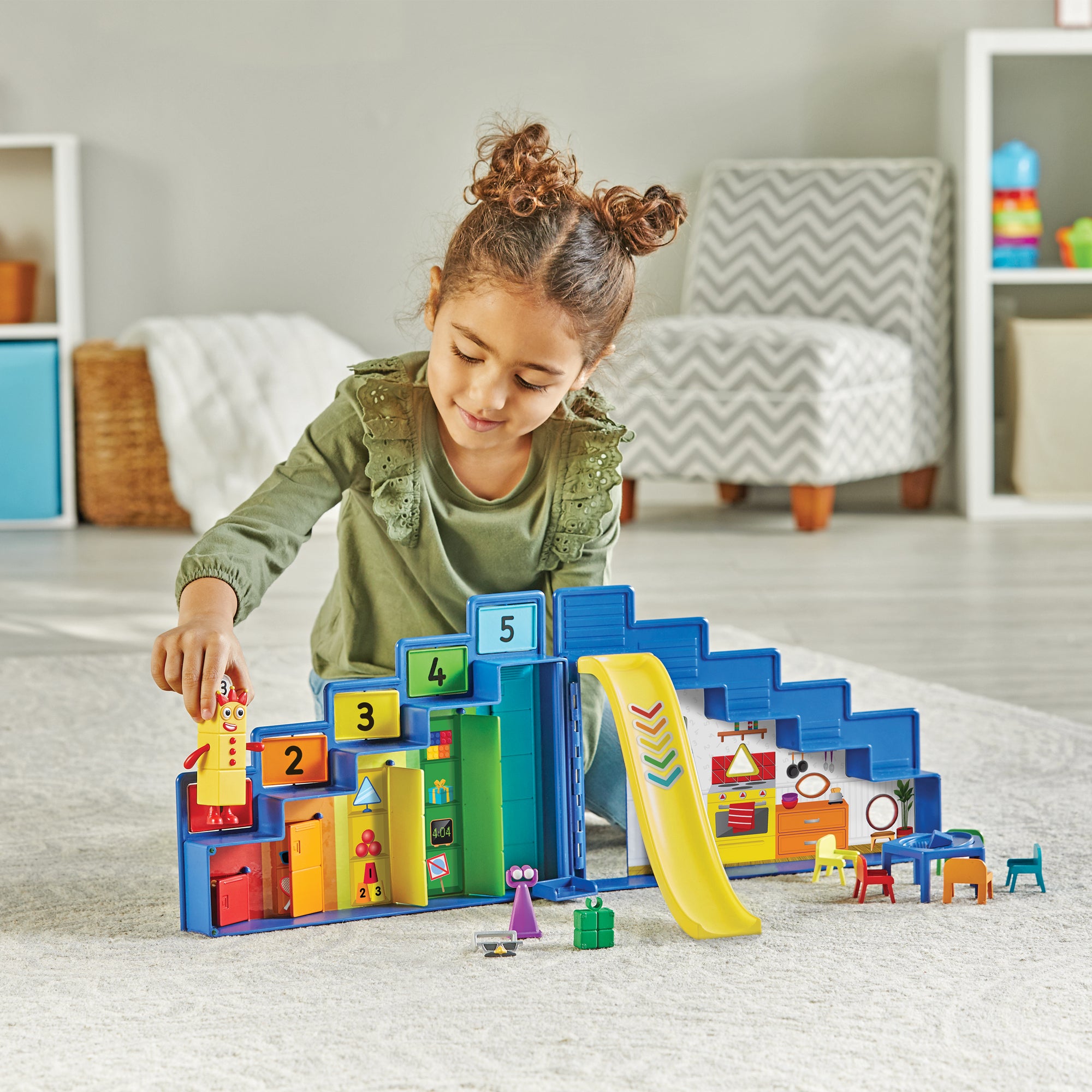 A young child playing with the Numberblocks Step Squad Mission Headquarters play set